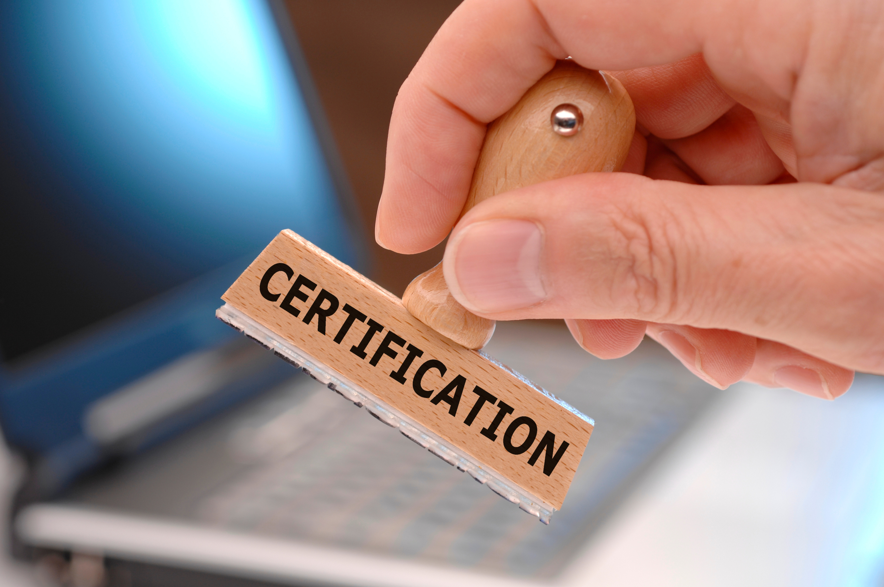certification printed on rubber stamp in hand